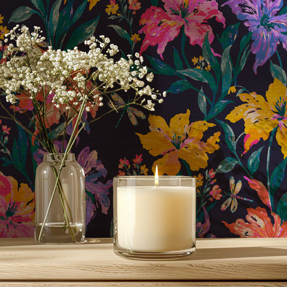 Close-up of Evening Bloom Firefly Social floral wallpaper behind a lit candle and a vase of baby's breath